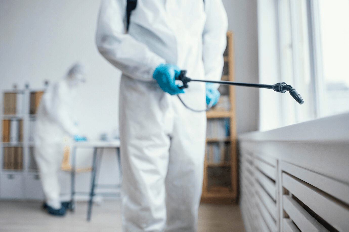 An exterminator disinfecting an area